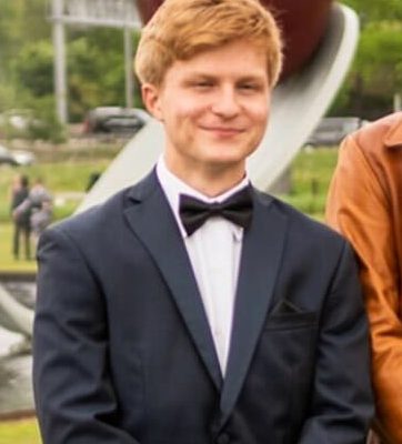 young man in suit standing and smiling