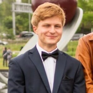 young man in suit standing and smiling