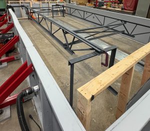2 steel joists with cross-bracing sitting inside a timber vacuum box chamber